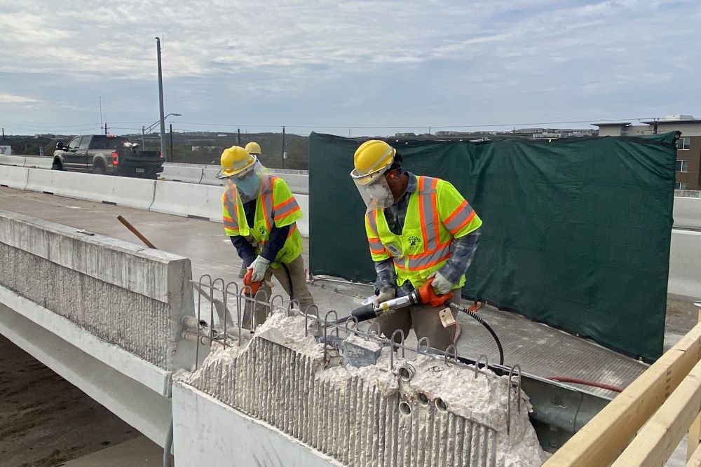 Oak Hill Parkway crews use jackhammers to remove the barrier on the US 290 overpass bridge at Old Fredericksburg Road. This bridge widening will make room for additional lanes of traffic on each side of US 290. March 2022