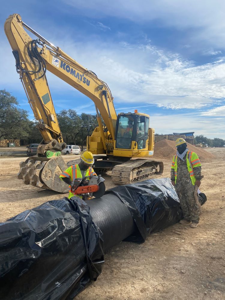 Oak Hill Parkway team members use a rotating saw to cut portions of a 30-inch pipe before it is placed in a trench. This pipe will serve as a main water transmission line to a community from a water treatment plant and feed smaller distribution lines. Jan