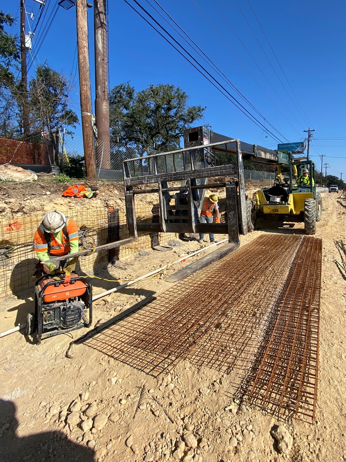 The team prepares to cut and place wire mesh to reinforce a retaining wall being built near US 290 and Circle Drive. December 2021