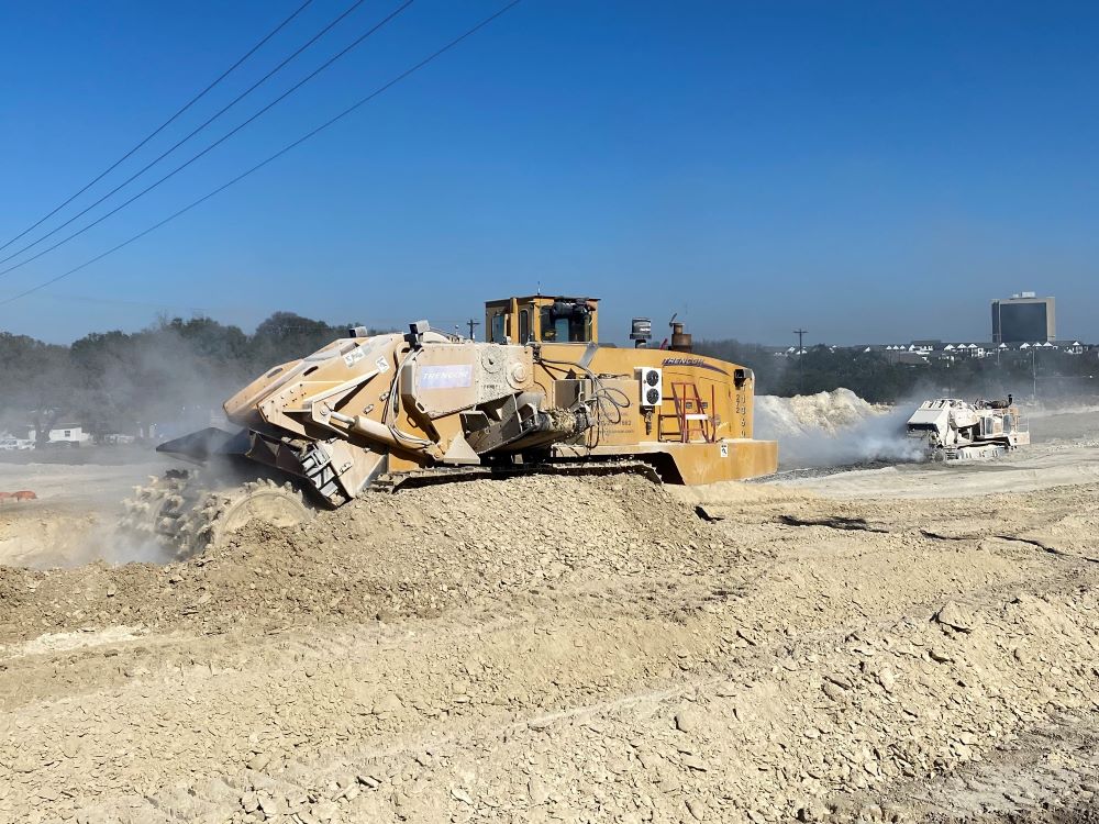 Two milling machines simultaneously work to crush heavy rock along US 290 near El Rey Boulevard. Project crews are lowering the grade for a section of the new eastbound US 290 frontage road being built. January 2022