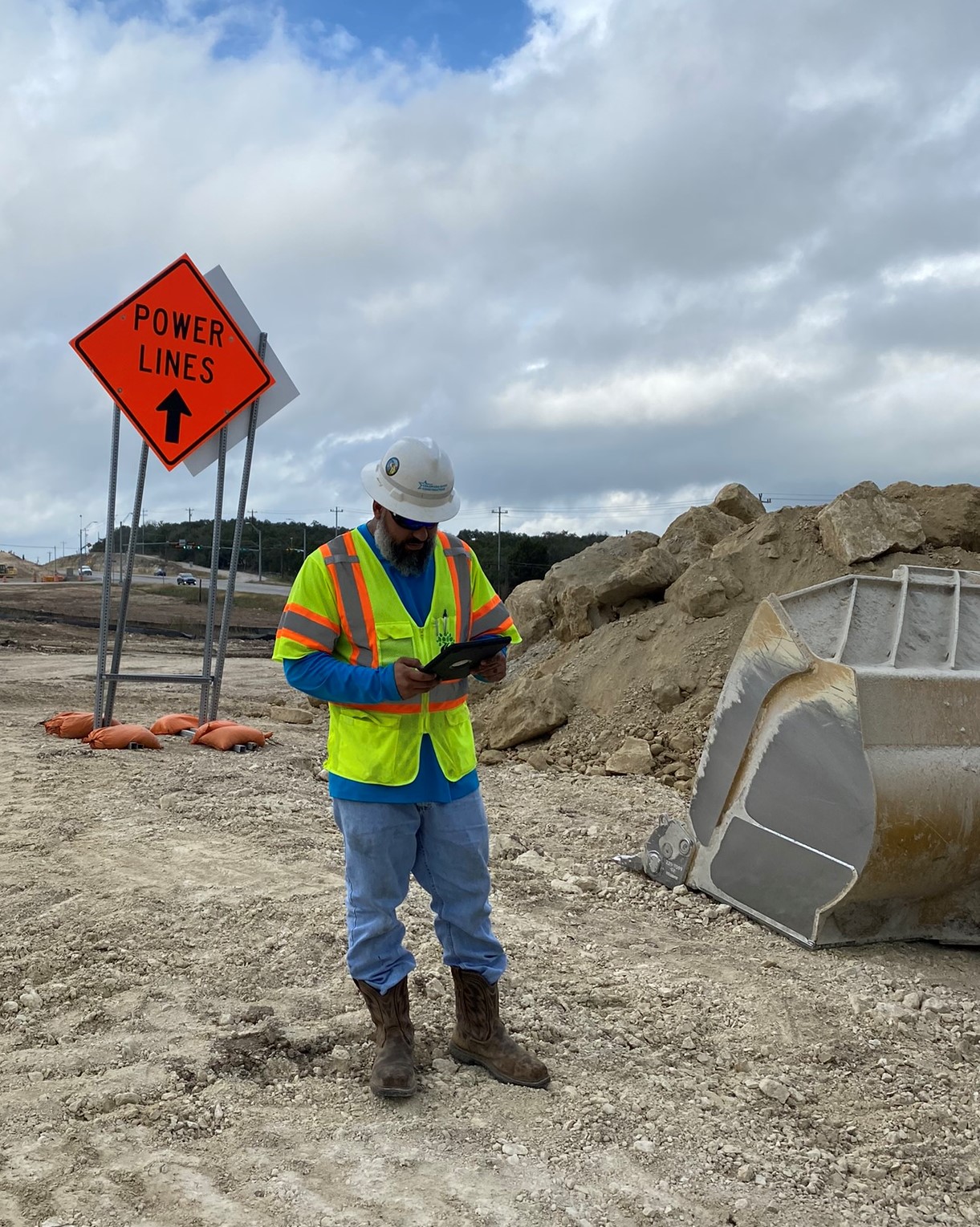 This earthwork foreman uses an iPad to manage safety analysis at the start of a workday. Proactive planning, including the placement of signage to alert workers to nearby utility lines, is essential to keeping construction teams as well as the public safe