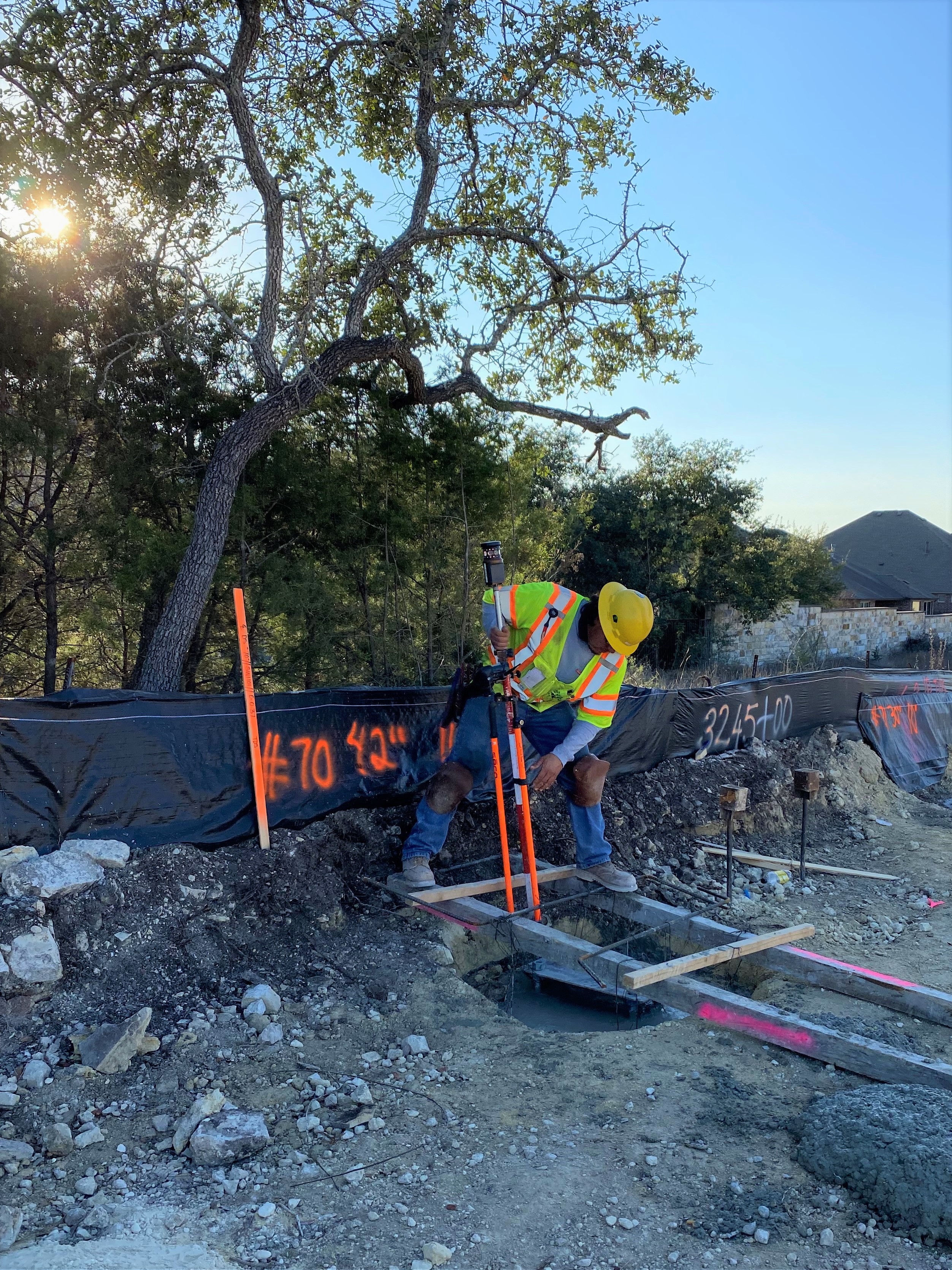 A surveyor performs a final check on a sound wall foundation near US 290 and South View Road. The sound wall will mitigate traffic noise after the Oak Hill Parkway project is completed. December 2021