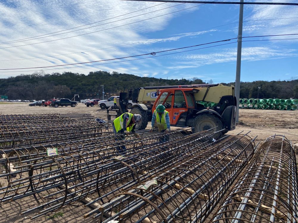 Oak Hill Parkway team members inspect newly delivered rebar to be used during construction of concrete bridge columns. These columns will hold up the new US 290 frontage road bridge near Old Bee Caves Road. March 2022