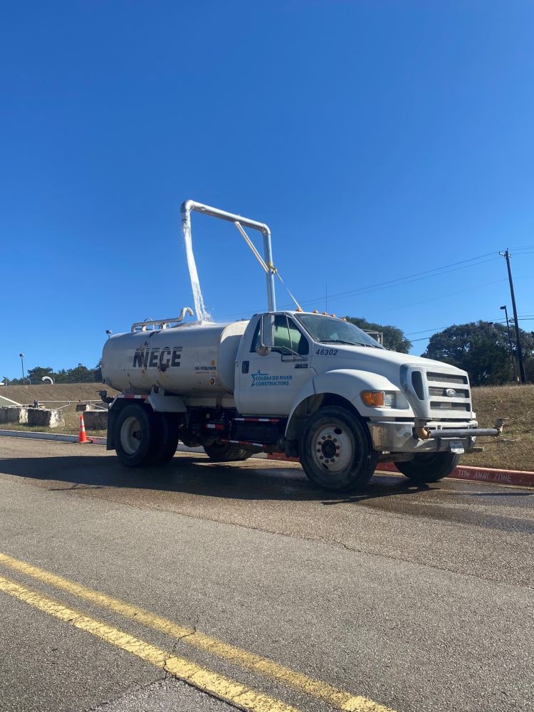 A water truck fills up before heading out to a work site. Spraying down active construction areas with water trucks is one of several dust mitigation methods being used during the Oak Hill Parkway project. January 2022
